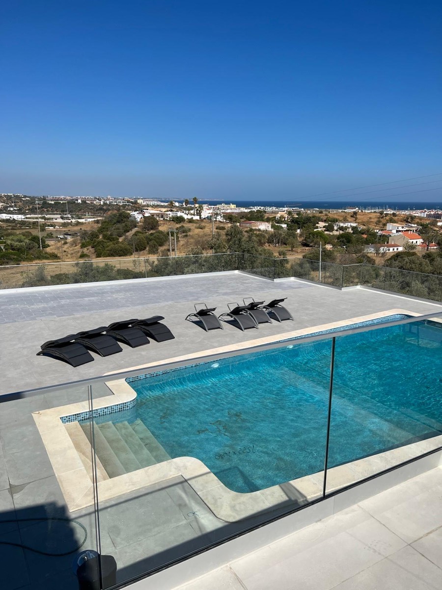 Piscina de cobertura com guarda de vidro e vista sobre a paisagem
